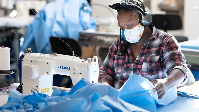 Person in a mask using a sewing machine