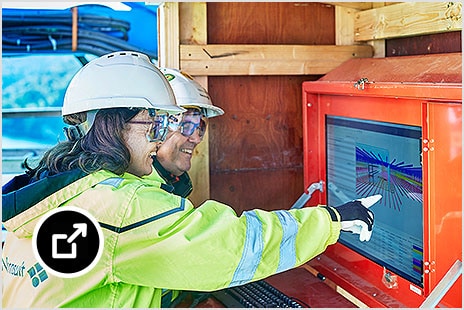 Construction workers looking at a screen on site 