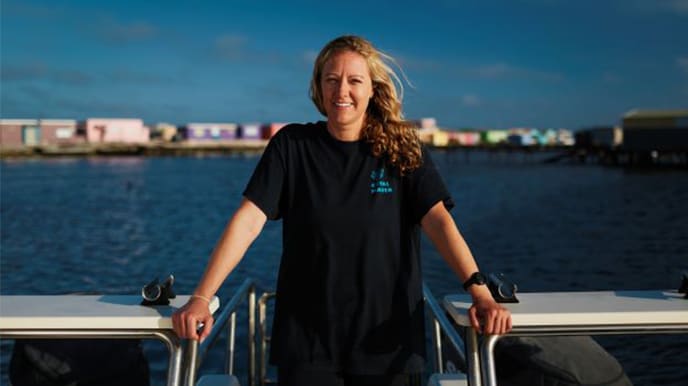 A woman on the back of dive boat preparing for coral reef restoration efforts.